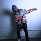 A picture of a black male model showing off the city chaos pullover by JCB ULTRA. A streetwear piece with a exclusive JCB ULTRA graffiti print. He is shown leaning to the side in a dramatic pose. 